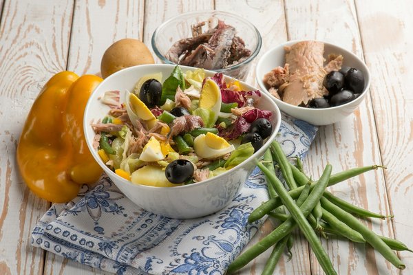 Comment élaborer une salade niçoise avec des anchois et œufs durs, à la manière traditionnelle ?